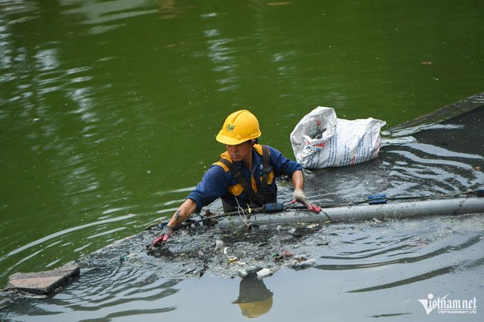 Công nhân môi trường thu gom rác trên sông Tô Lịch. Ảnh: Thạch Thảo
