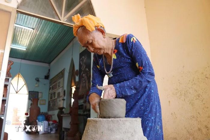 Nghệ nhân Trượng Thị Gạch miệt mài tham gia bảo tồn nghề gốm truyền thống tại Hợp tác xã gốm Chăm Bàu Trúc (xã Ninh Phước, Khánh Hòa). (Ảnh: Nguyễn Thành/TTXVN)