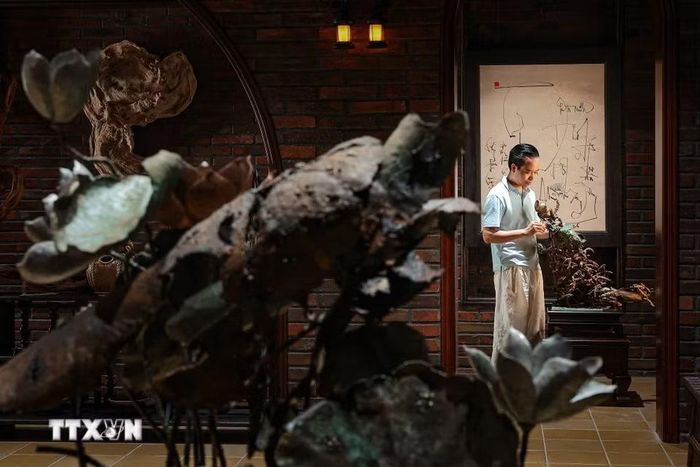 Nghệ nhân Bùi Văn Tự hoàn thiện chi tiết trên tác phẩm “Cá chuối đắm đuối vì con”. Theo anh, chế tác bằng đồng đòi hỏi kỹ năng gia công kim loại và xử lý sự biến dạng nhiệt để bảo đảm hình khối, bóng đổ theo ý tưởng sáng tác. (Ảnh: Phạm Tuấn Anh/TTXVN)
