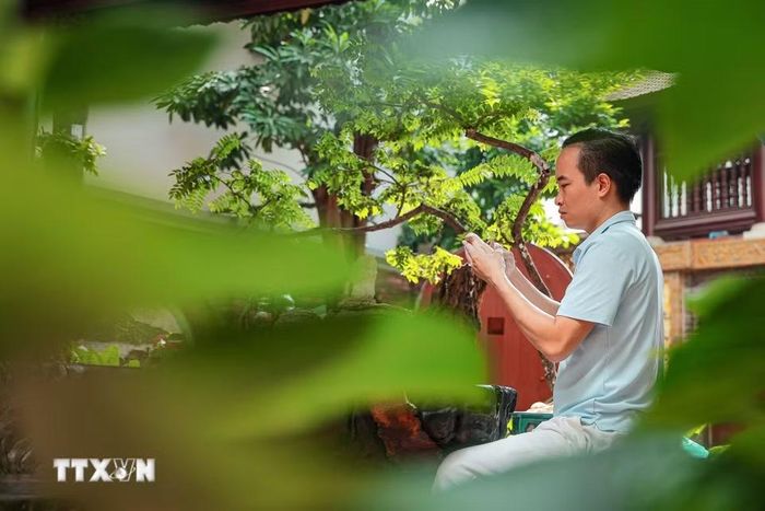 Nghệ nhân Bùi Văn Tự chăm chút mẫu tạo hình bằng đất sét. (Ảnh: Phạm Tuấn Anh/TTXVN)