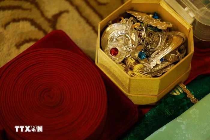 Các món trang sức và phụ kiện như vòng, dây đeo, vật trang trí được sắp xếp trước khi diễn ra nghi lễ hầu đồng. Cùng với khăn áo và đạo cụ, những phụ kiện này góp phần tạo nên diện mạo riêng của thanh đồng trong từng giá hầu. Sự chuẩn bị tỉ mỉ cho thấy nghi lễ hầu đồng bao gồm nhiều công đoạn và đòi hỏi sự am hiểu về trang phục, vật phẩm truyền thống. (Ảnh: Phạm Tuấn Anh/TTXVN)