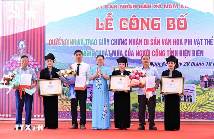Phó Giám đốc Sở Văn hóa, Thể thao và Du lịch tỉnh Điện Biên Nguyễn Thị Thanh Chuyên trao Giấy chứng nhận Di sản văn hóa phi vật thể nghệ thuật múa của người Cống tỉnh Điện Biên. (Ảnh: TTXVN phát)