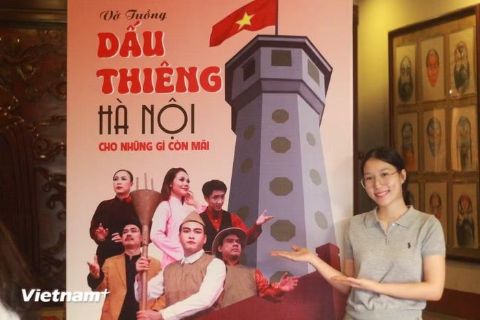 Khán giả Minh Anh (19 tuổi) lưu lại khoảnh khắc kỷ niệm cùng backdrop tác phẩm "Dấu thiêng Hà Nội - Cho những gì còn mãi" .(Ảnh: Đức Hiếu/Vietnam+)