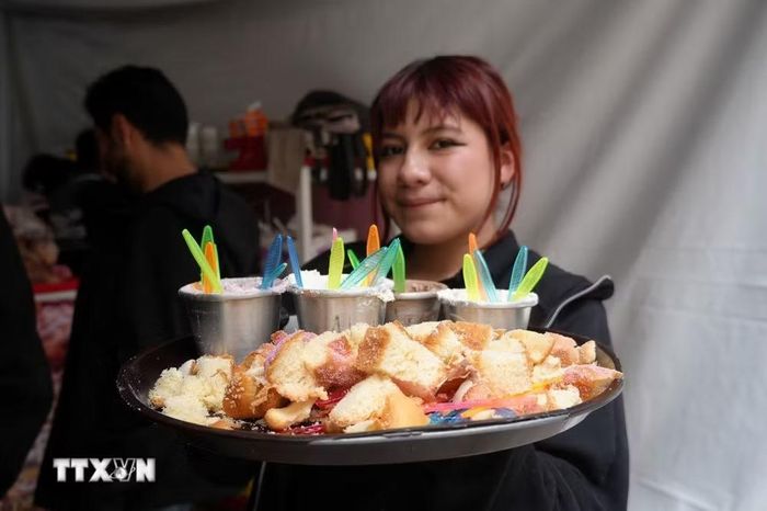 Cô gái trẻ giới thiệu bánh Pan de muerto cho khách ăn thử trong một hội chợ tại thủ đô Mexico City, Mexico. (Ảnh: Phi Hùng/TTXVN)