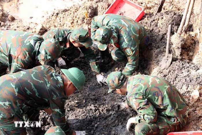 Cán bộ, chiến sỹ đội K74 đẩy mạnh tiến độ tìm kiếm, quy tập hài cốt liệt sỹ tại công viên Lê Thị Riêng. (Ảnh: Xuân Khu/TTXVN)