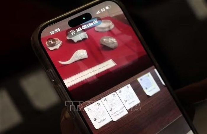 Du khách có thể tra cứu thông tin hiện vật qua mã QR Code trên điện thoại thông minh tại Bảo tàng tỉnh Hưng Yên. Ảnh: Đinh Văn Nhiều/TTXVN