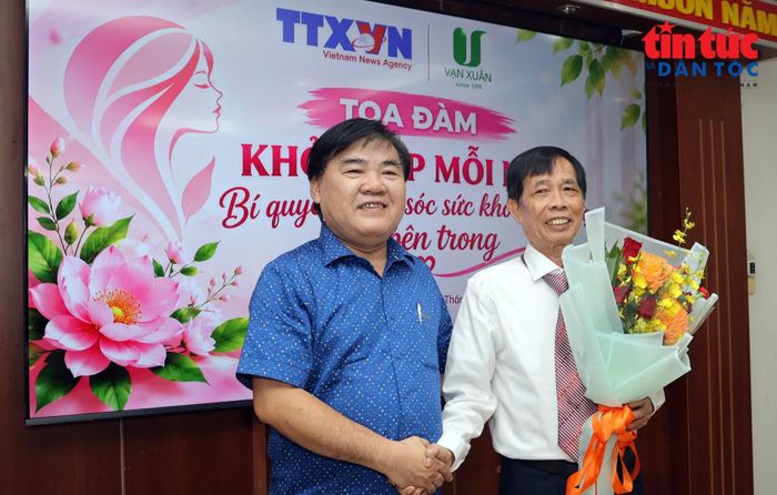Ông Nguyễn Quốc Tuấn, Bí thư Đảng ủy, Giám đốc Trung tâm Thông tin TTXVN khu vực phía Nam tặng hoa cám ơn các diễn giả tham gia tại toạ đàm.