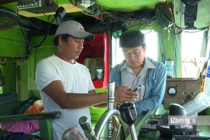 Ngư dân Nguyễn Thanh Ân (bên trái ảnh) giới thiệu về ứng dụng nhật ký khai thác điện tử trên tàu cá.