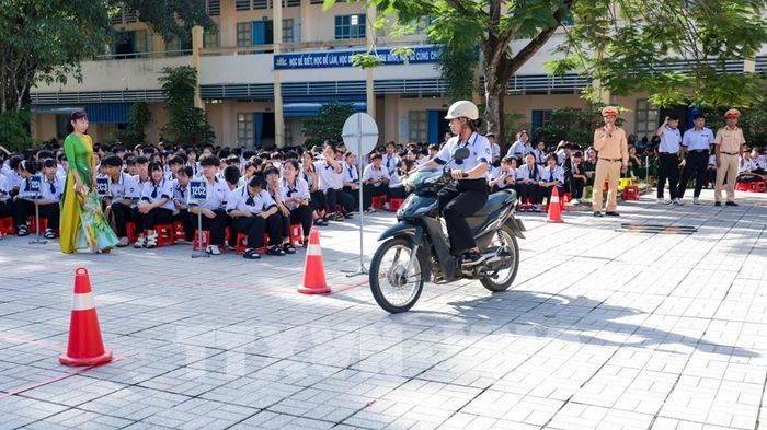 Học sinh Tây Ninh thực hành điều khiển xe mô tô theo hướng dẫn của cán bộ Cảnh sát giao thông. Ảnh: Minh Phú - TTXVN