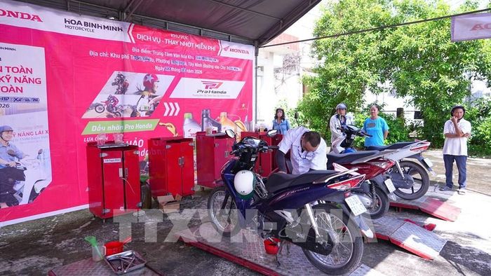 Người dân Tây Ninh được thay nhớt xe mô tô, xe máy miễn phí khi tham giam chương trình. Ảnh: Minh Phú - TTXVN