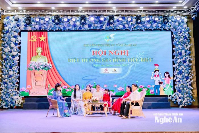 Gia đình chị Huỳnh Thị Hòa (áo dài đỏ) tham gia tọa đàm tại lễ tuyên dương. Ảnh: P.V