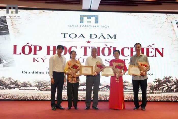 Các nhân chứng tham dự tọa đàm nhận hoa chúc mừng từ lãnh đạo Bảo tàng Hà Nội