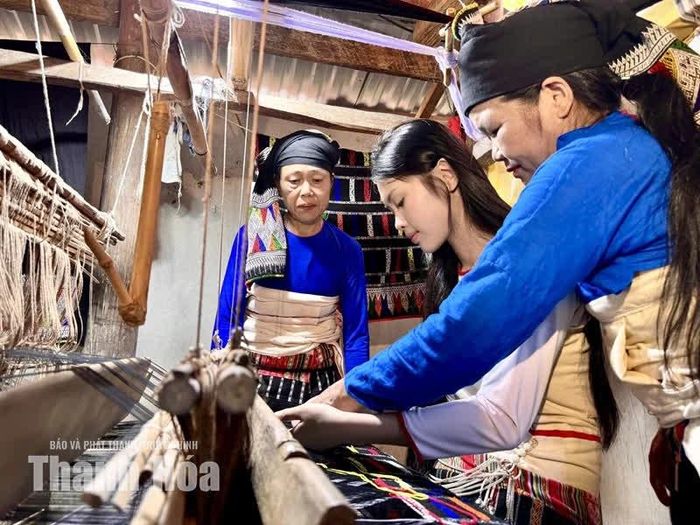 Bà Lò Thị Mắn cùng phụ nữ trong thôn truyền dạy nghề dệt thổ cẩm cho lớp trẻ.