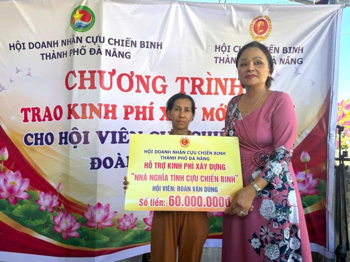 Bà Hồ Thị Thắng (bên phải) trao 60 triệu đồng hỗ trợ xây dựng nhà cho gia đình cựu chiến binh Đoàn Văn Dũng (xã Thăng An). Ảnh: XUÂN ĐÔNG