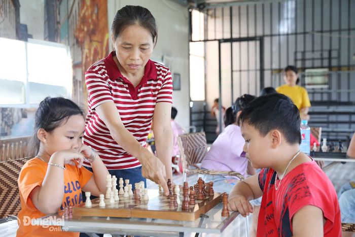 Cô Lê Thị Hợi hướng dẫn các em làm quen với cờ vua, cờ tướng. Ảnh: Huy Anh