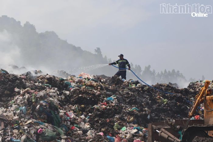 Công nhân phun nước dập lửa, giảm thiểu khói bụi ở Bãi rác Hòn Ngang, xã Diên Lâm.