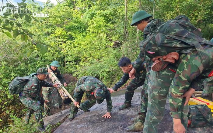Cán bộ, chiến sĩ hỗ trợ nhau vượt qua gộp đá cao, trơn trượt.