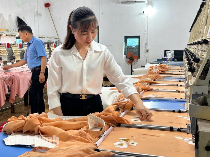 Chị Dương Thị Tuyết kiểm tra từng đường thêu họa tiết trên dây chuyền thêu vi tính hiện đại tại xưởng sản xuất. Ảnh: Nguyễn Lựu