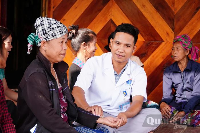 Bác sĩ Hồ Văn Khăm thăm khám tại nhà cho người dân bản La Trọng, xã Dân Hóa - Ảnh: Q.N