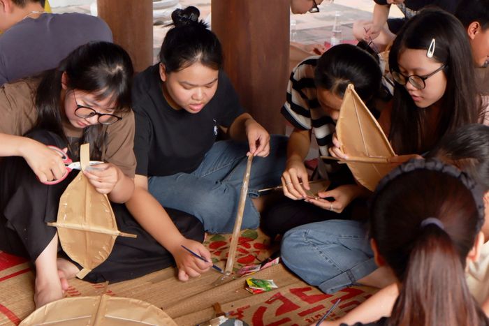 Các bạn trẻ thích thú khi tự tạo ra con diều của riêng mình. (Ảnh: Hương Giang)