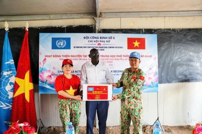 Thiếu tá Nguyễn Văn Linh, Chính trị viên Đội Công binh số 5, và Thượng tá QNCN Nguyễn Thị Hiền, Chi hội trưởng Chi hội Phụ nữ Đội Công binh số 5, trao quà tặng nhà trường. Ảnh: Đức Uy