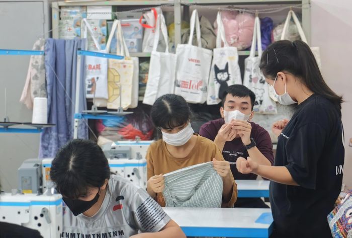 Cô Phan Thị Yến (bìa phải) dạy các em học may bằng ngôn ngữ ký hiệu.