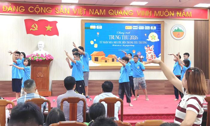 Cô giáo Đỗ Thu Trang (góc phải) lặng lẽ đứng dưới sân khấu, hướng dẫn từng động tác trong tiết mục văn nghệ của học sinh tự kỷ.