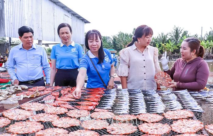 Phó Chủ tịch Hội LHPN tỉnh Nguyễn Thị Ngọc Thuý (thứ hai từ phải sang) thăm mô hình sản xuất cá khô của chị Võ Thị Lệ Huyền, Chi hội trưởng Chi hội Phụ nữ ấp Mỹ Bình (bìa phải).