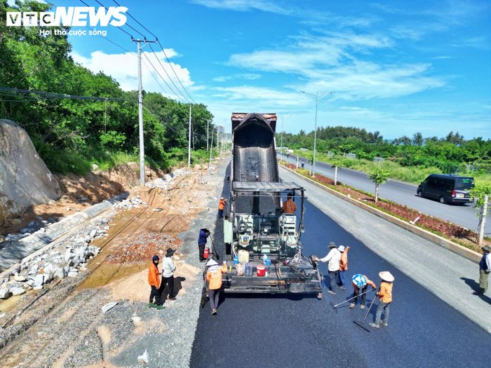 Các đơn vị huy động nhân lực, máy móc tập trung thảm nhựa mặt đường. Dải phân cách giữa các làn xe đã được trồng cây xanh, trong khi nhiều hạng mục tiếp tục được hoàn thiện.