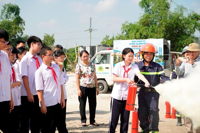 Lực lượng chức năng hướng dẫn cách sử dụng bình cứu hỏa an toàn, hiệu quả. Ảnh: Đinh Luyện