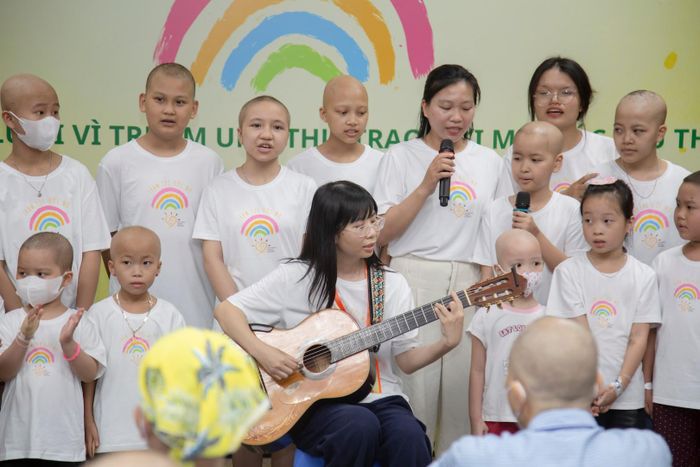 Chị Hoàng Thị Diệu Thuần (cầm đàn ghita) cùng các bệnh nhi mang đến những giai điệu lan tỏa niềm vui, sự lạc quan tại ngày hội. Ảnh: PV