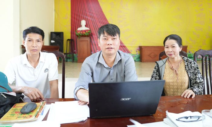 Ông Nguyễn Văn Nam hỗ trợ người dân cập nhật dữ liệu đất đai tại nhà văn hoá thôn. Ảnh: Thanh Xuân