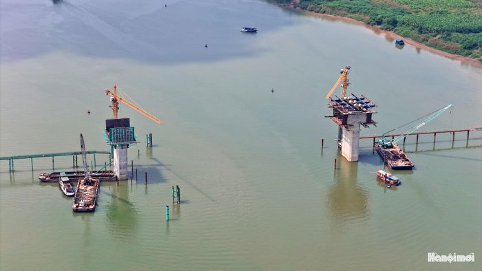 Những trụ cầu bê tông vươn cao giữa không gian sông nước cho thấy quy mô và độ phức tạp của công trình vượt sông Hồng, đòi hỏi kỹ thuật thi công, kiểm soát chất lượng nghiêm ngặt.