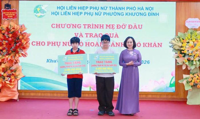 Phó Chủ tịch Thường trực Hội Liên hiệp phụ nữ thành phố Hà Nội Phạm Thị Thanh Hương trao chương trình Mẹ đỡ đầu cho 2 trẻ mồ côi phường Khương Đình có hoàn cảnh khó khăn. Ảnh: Nguyễn Kiên