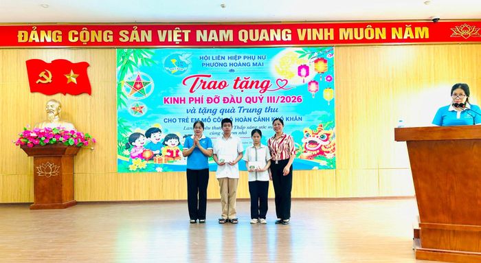 Chủ tịch Hội LHPN phường Hoàng Mai Nguyễn Thị Kim Thu cùng cán bộ chi hội trao kinh phí đỡ đầu cho các em nhỏ. Ảnh: Trần Oanh