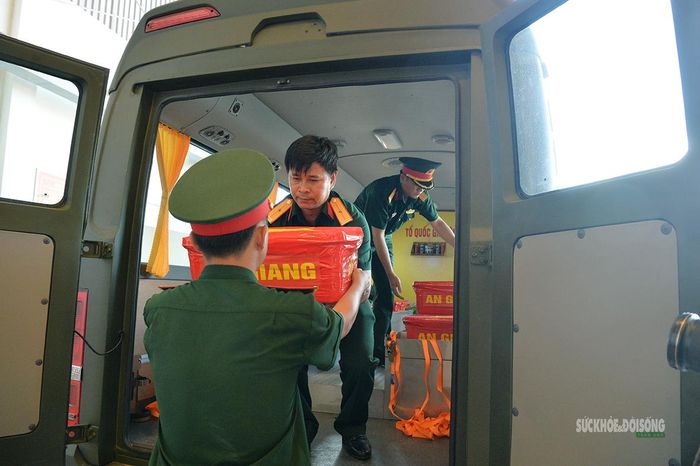 Cán bộ, chiến sĩ đưa các thùng chứa mẫu sinh phẩm hài cốt liệt xuống khu vực bàn giao. Ảnh: Tuấn Anh