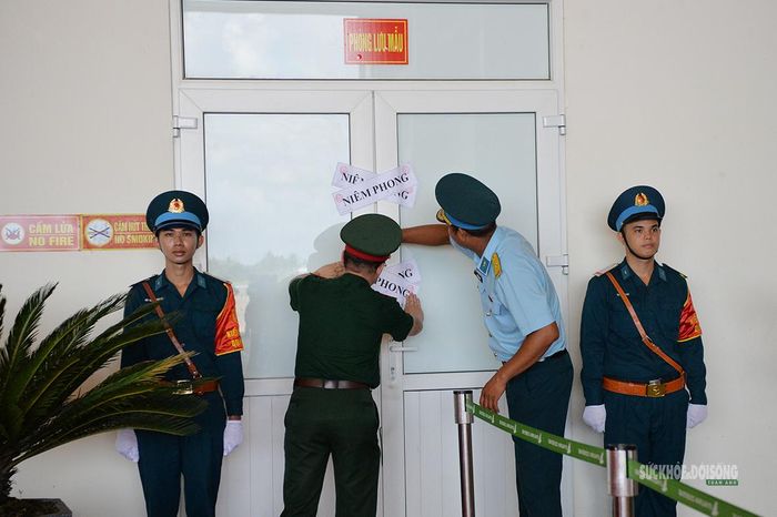 Đại diện các đơn vị phối hợp niêm phong phòng lưu giữ mẫu sinh phẩm sau khi hoàn tất kiểm tra. Ảnh: Tuấn Anh