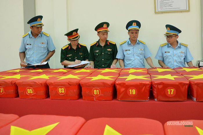 Cán bộ các đơn vị phối hợp kiểm tra, đối chiếu các thùng chứa mẫu sinh phẩm trước khi niêm phong. Ảnh: Tuấn Anh