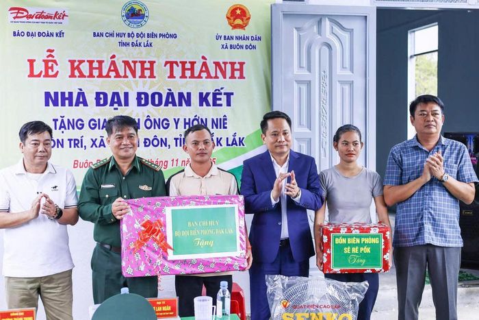 Ông Trương Thành Trung, Tổng Biên tập báo Đại đoàn kết và Đại tá Rơ Lan Ngân, Phó Chính ủy Bộ Chỉ huy Bộ đội Biên phòng tỉnh Đắk Lắk bàn giao nhà cho con ông Y Hớn Niê. Ảnh: Quang Vinh.