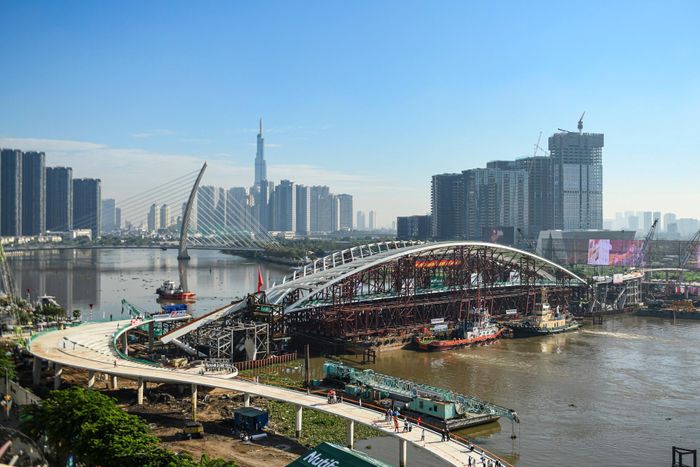  Trước đó, các đơn vị thi công đã chuẩn bị xuyên đêm cho sự kiện này. Từ 5h sáng 21/10, đoàn lai dắt hoàn thành việc xoay ngang sà lan chở vòm thép nặng 3.400 tấn, di chuyển vào trụ đỡ 2 đầu; sau đó tiến hành định vị, hiệu chỉnh và hạ tải. 