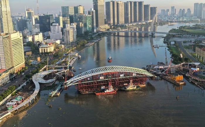 Toàn cảnh sà lan chở nhịp chính được đưa vào vị trí hợp long dự án cầu đi bộ qua sông Sài Gòn. Ảnh: Mịnh Linh -TTXVN