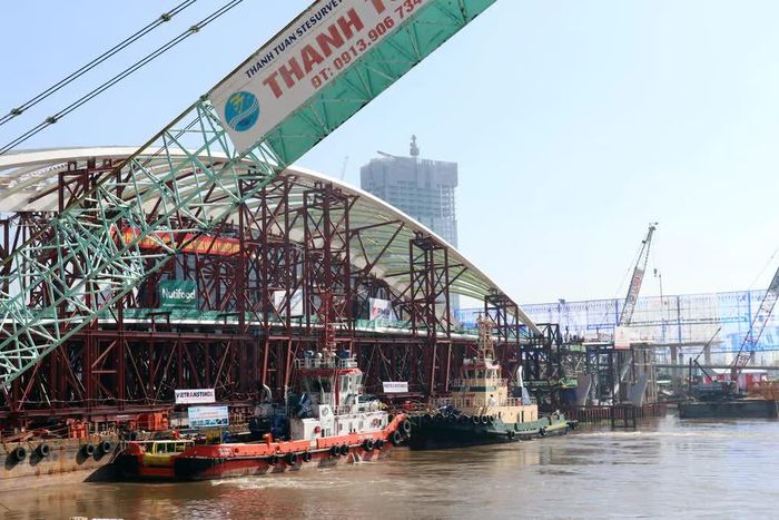 Vòm thép dài 187m được các tàu lai dắt vào mố trụ cầu. Ảnh: Tiến Lực - TTXVN