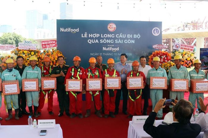 Lãnh đạo TP. Hồ Chí Minh và các đơn vị tặng quà cho nhà thầu thi công dự án cầu đi bộ qua sông Sài Gòn. Ảnh: Tiến Lực - TTXVN