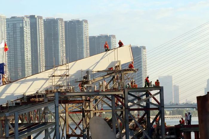 Các kỹ sư, công nhân làm việc trên công trường, chuẩn bị cho quá trình hợp long dự án cầu đi bộ qua sông Sài Gòn. Ảnh: Tiến Lực - TTXVN