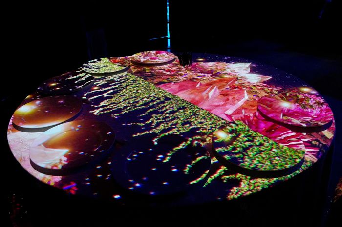 Hiệu ứng 3D Mapping được trình chiếu trên bàn tiệc, tạo nên trải nghiệm thị giác độc đáo, kết hợp nghệ thuật biểu diễn với không gian ẩm thực. Ảnh: BTC