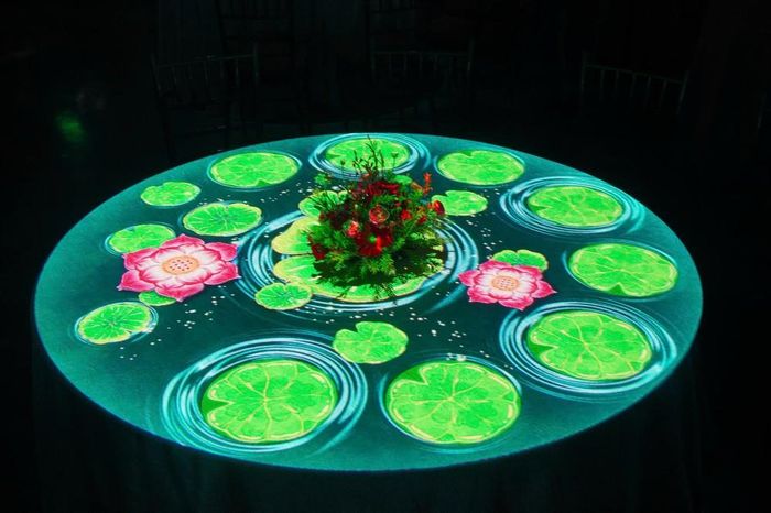 Hiệu ứng 3D Mapping được trình chiếu trên bàn tiệc, tạo nên trải nghiệm thị giác độc đáo, kết hợp nghệ thuật biểu diễn với không gian ẩm thực. Ảnh: BTC