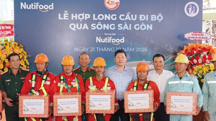 Lãnh đạo Ủy ban nhân dân Thành phố Hồ Chí Minh trao quà động viên công nhân, kỹ sư cùng các nhà thầu thi công cầu đi bộ tại Lễ hợp long (Ảnh: VÕ LÊ)