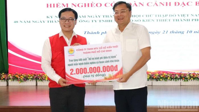 Lãnh đạo Công ty Trách nhiệm hữu hạn MTV Xổ số Kiến thiết Thành phố Hồ Chí Minh trao số tiền hỗ trợ đến Hội Chữ thập đỏ Thành phố Hồ Chí Minh. (Ảnh: VƯƠNG LÊ)