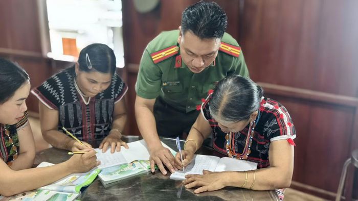 Cán bộ công an xã A Vương trực tiếp đứng lớp, hướng dẫn đồng bào Cơ Tu học tiếng Việt. (Ảnh: HỮU KHÁNH)