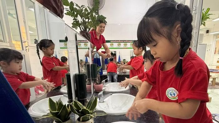 Các em học sinh Trường mầm non Tân Lập (xã Ô Diêm, Thành phố Hà Nội) thực hiện việc rửa tay bằng xà-phòng để phòng bệnh tay chân miệng. (Ảnh: VÂN VÂN)